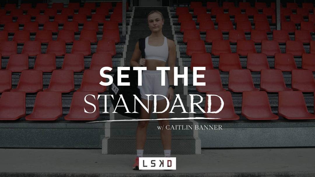 girl standing at an athletics track with her bag