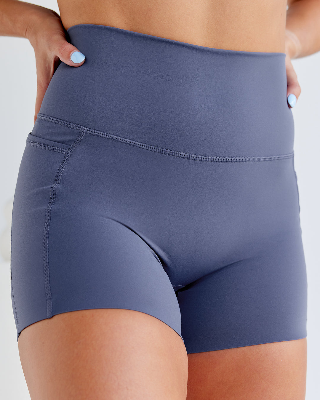 Woman wearing Abs Elixir X-Short Tights With Pockets - Nightshadow Blue