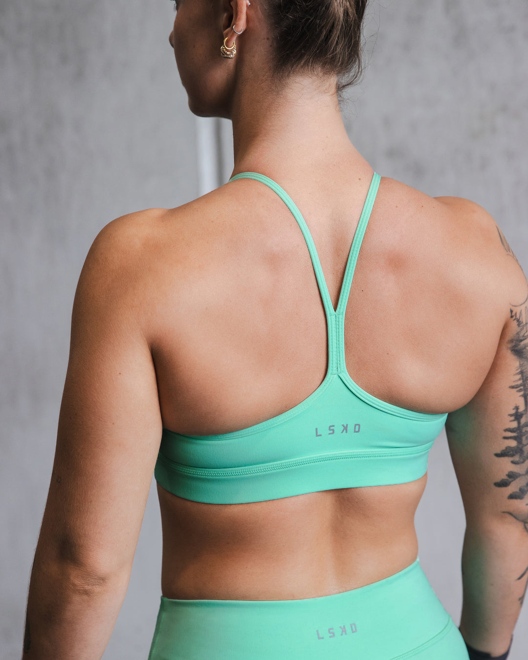 Woman wearing Lift High Neck Sports Bra - Cockatoo