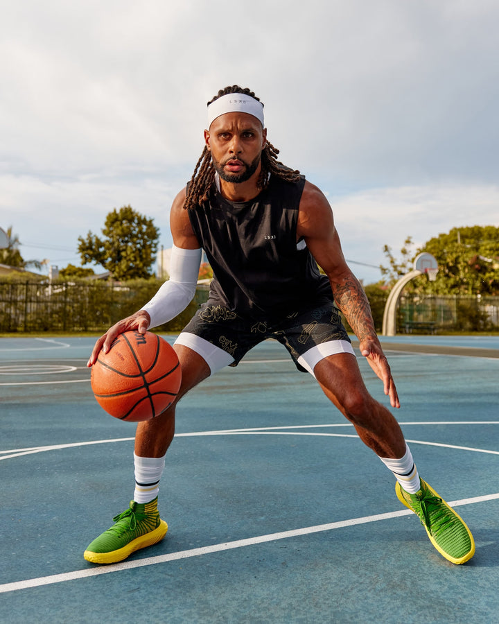 Man wearing Patty Mills Challenger 6&quot; Performance Shorts - Black-Vital Green
