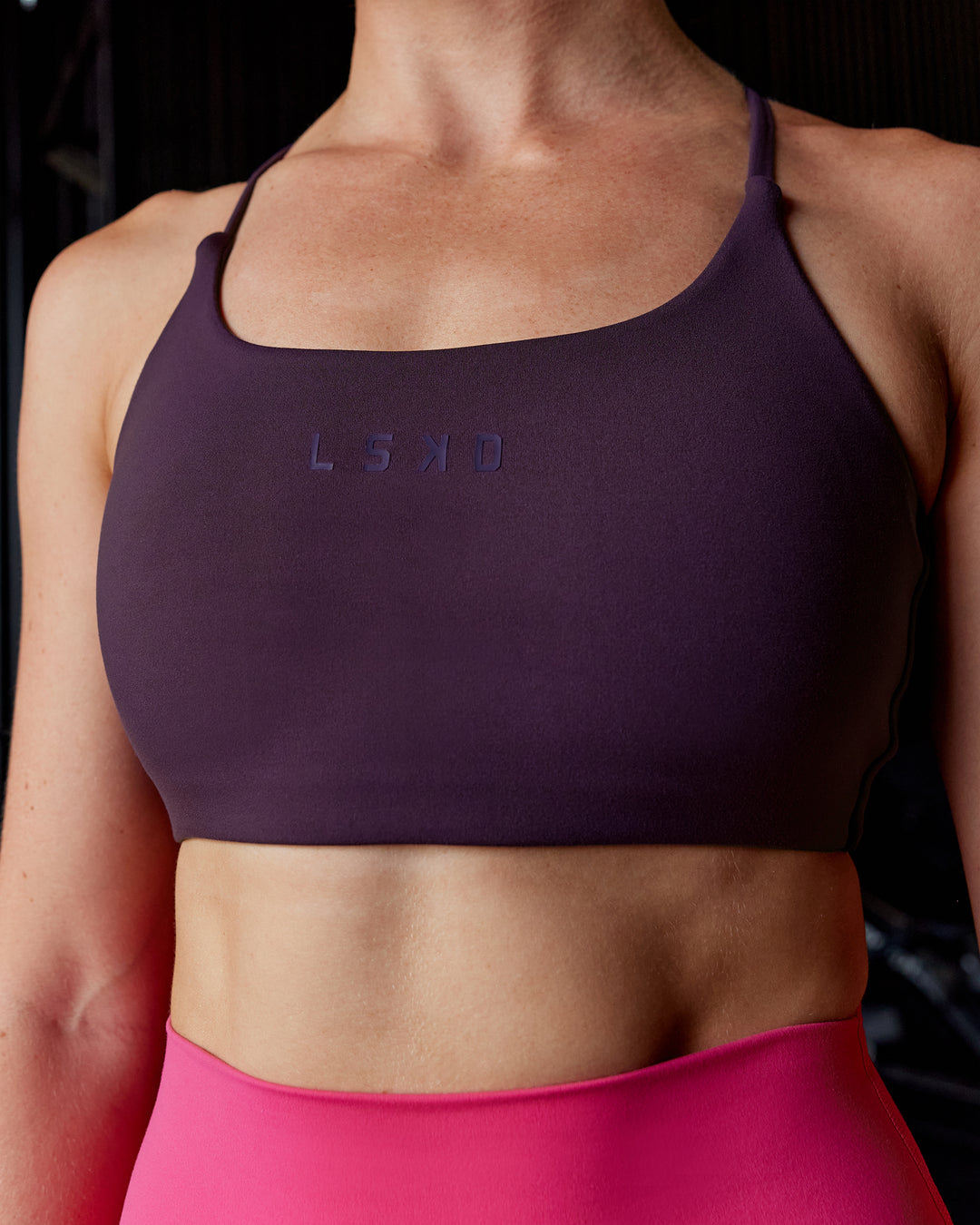 Woman wearing Twist Sports Bra - Midnight Plum