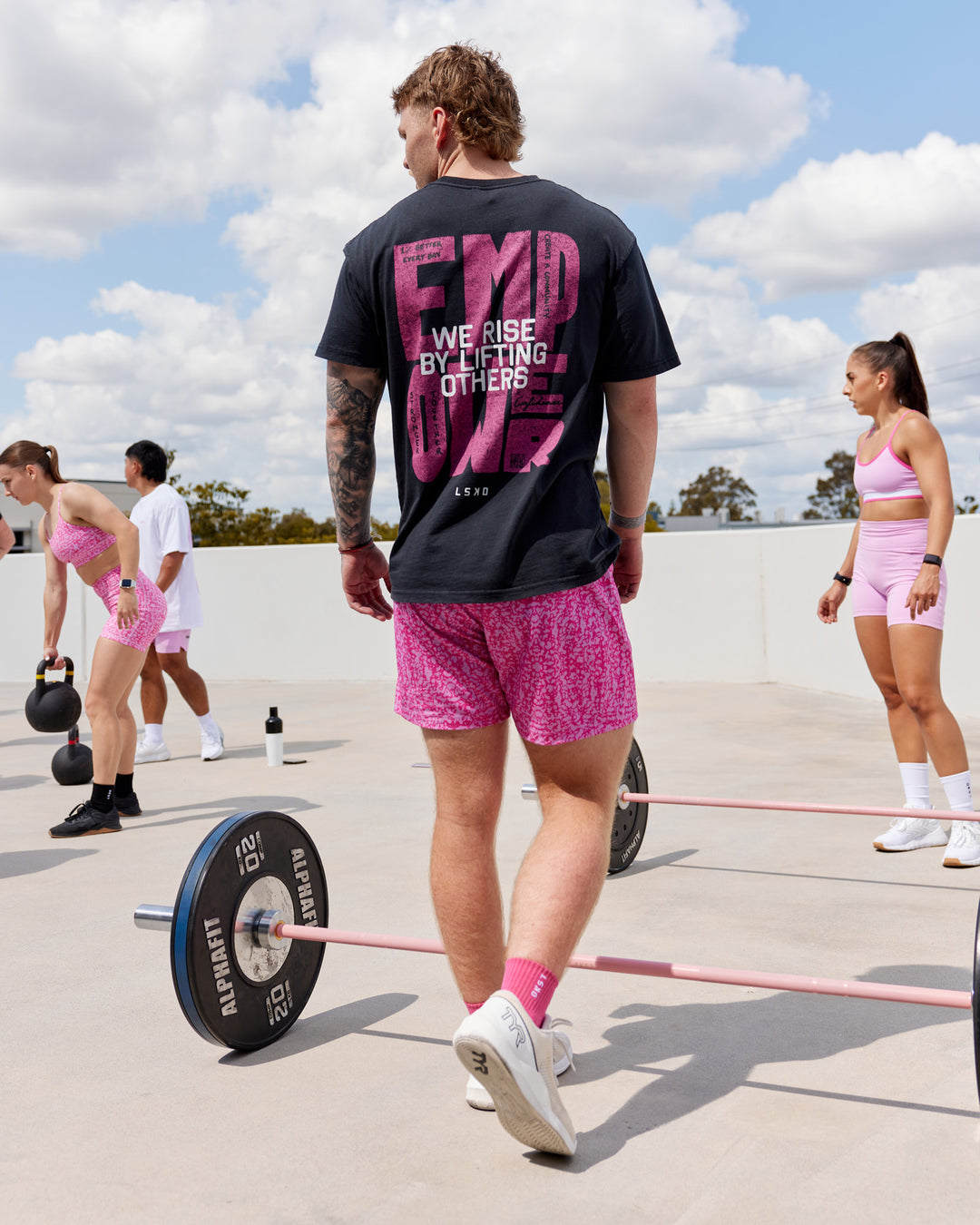 Man wearing Unisex Washed Empower Tee Oversize - Black-Berry Pink