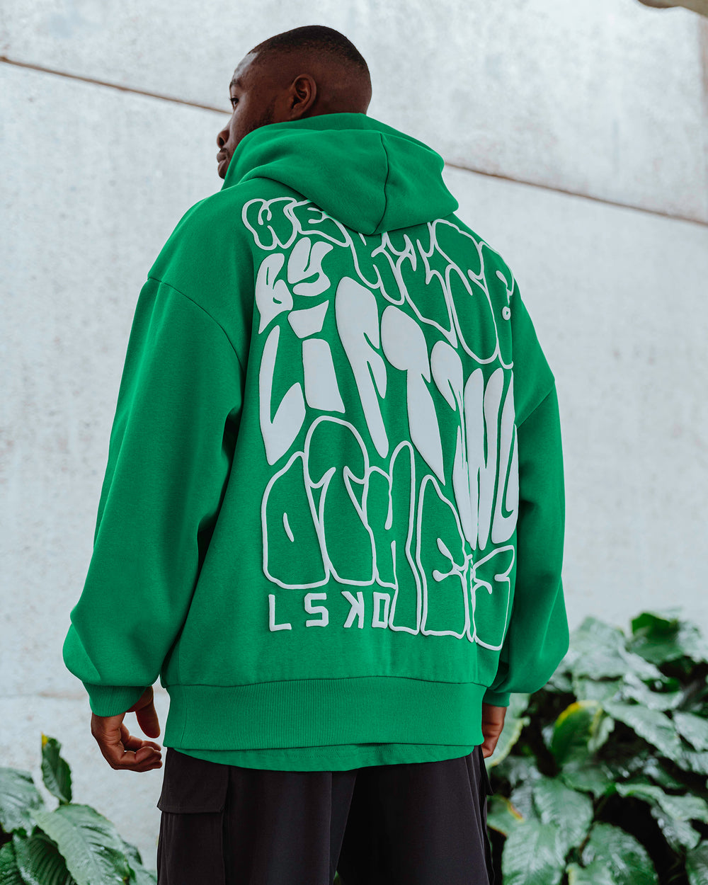 Man wearing Unisex We Rise Hoodie Oversize - Impact Green-White