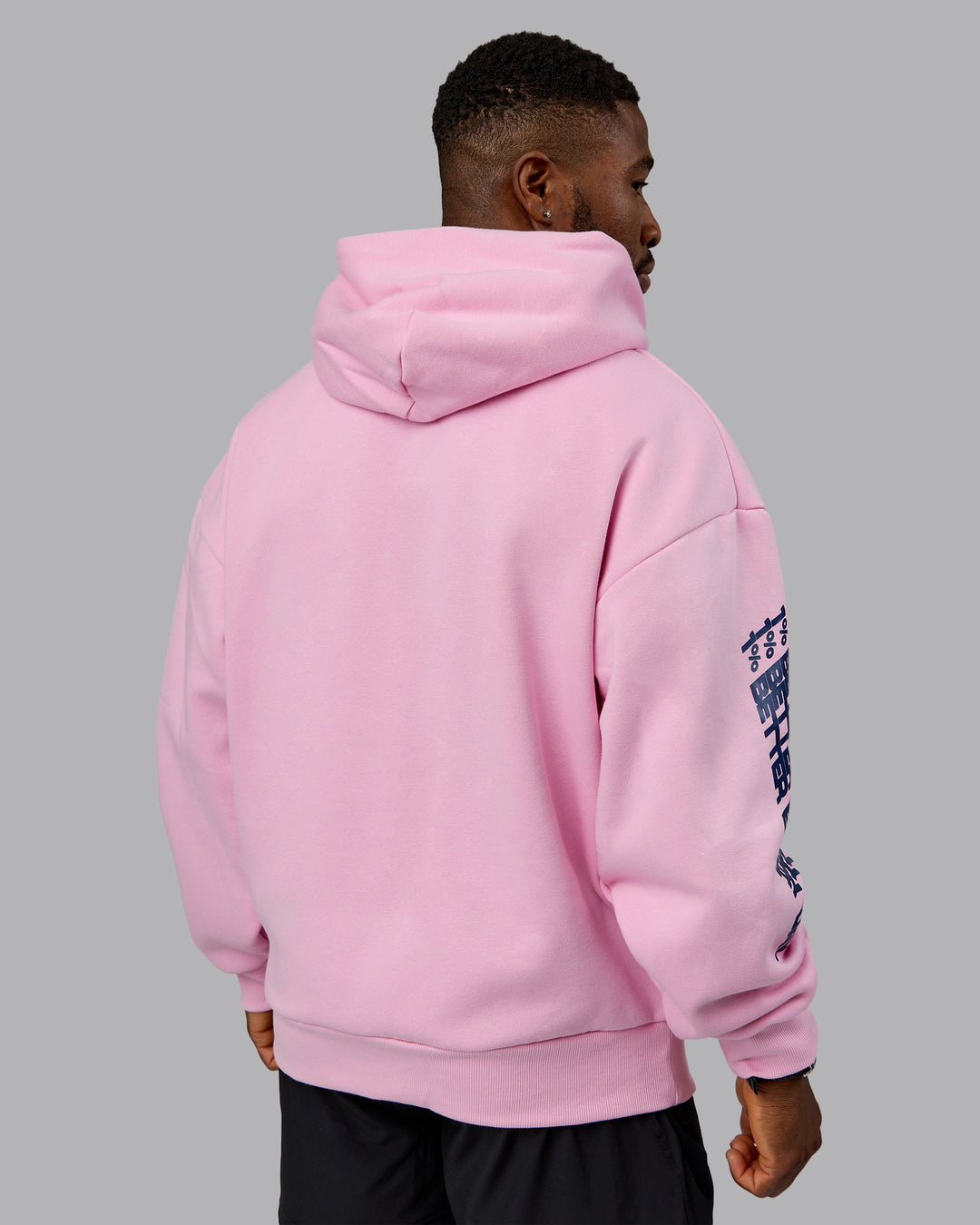 Man wearing Displacement Oversized Hoodie - Light Bubblegum-Dark Moss | Model:Sam | Size:L