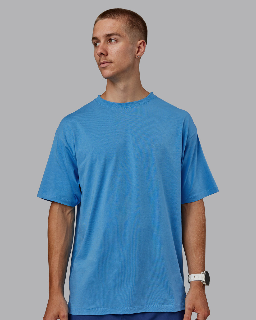 Man wearing Unisex PimaFLX Tee Oversize in Azure Blue | Size:L