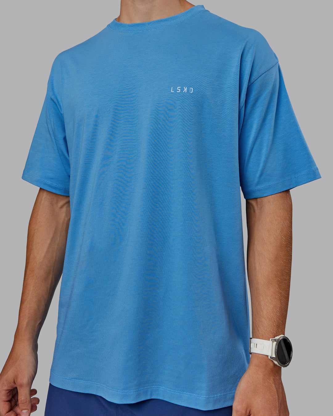 Man wearing Unisex PimaFLX Tee Oversize in Azure Blue | Size:L