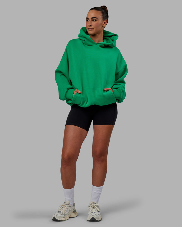 Woman wearing Unisex We Rise Hoodie Oversize - Impact Green-White
