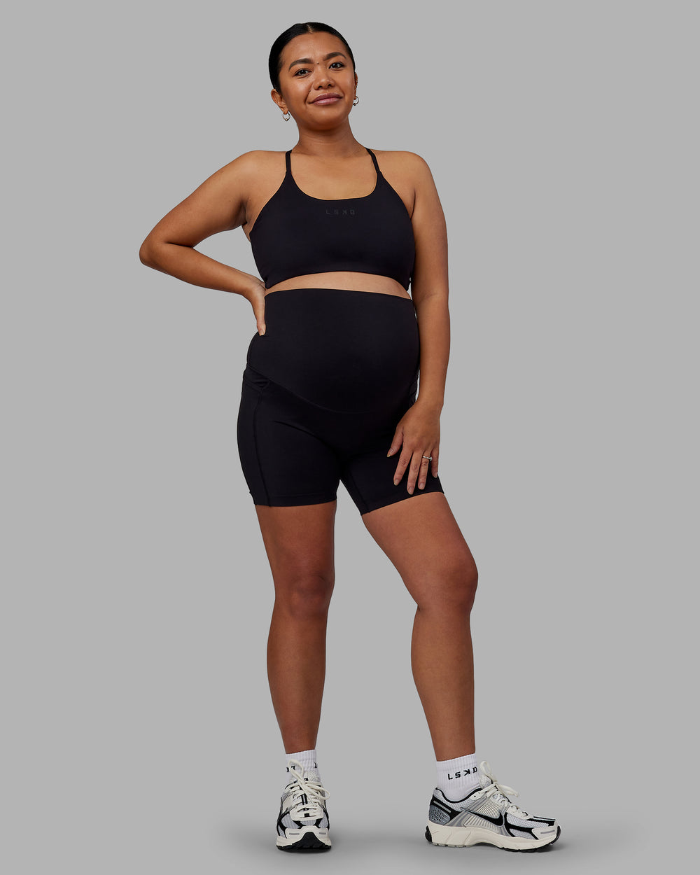 Woman wearing Elixir Maternity Mid Short Tights With Pockets - Black