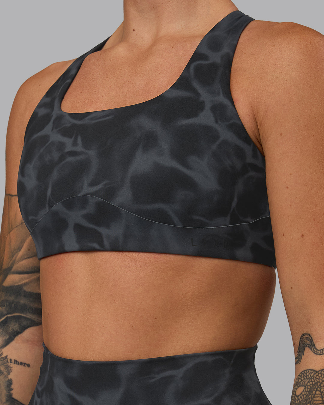 Woman wearing Aspire Sports Bra - Tranquil-Black