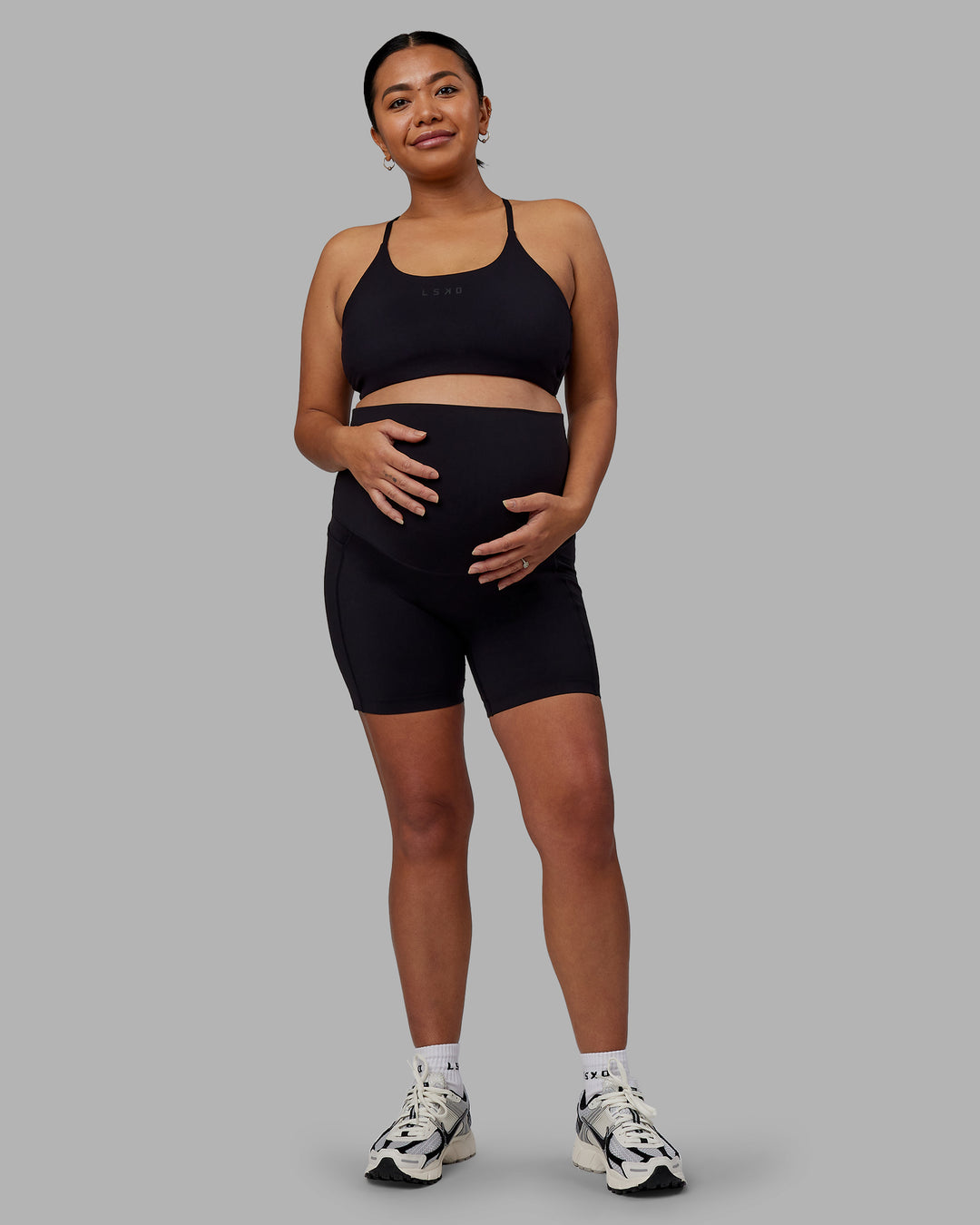 Woman wearing Elixir Maternity Mid Short Tights With Pockets - Black