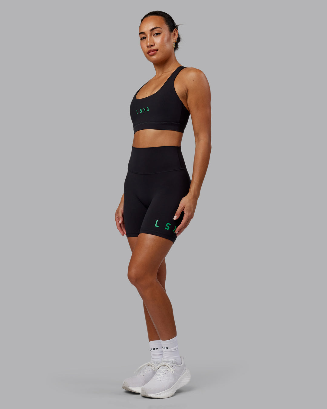 Woman wearing Evolved Mid Short Tights - Black-Impact Green