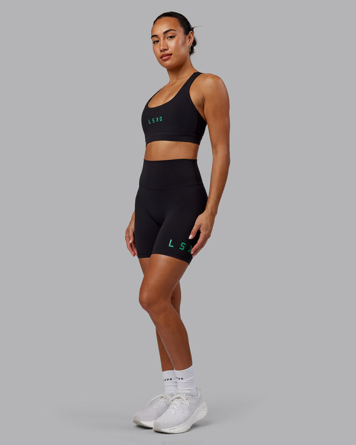 Woman wearing Evolved Mid Short Tights - Black-Impact Green
