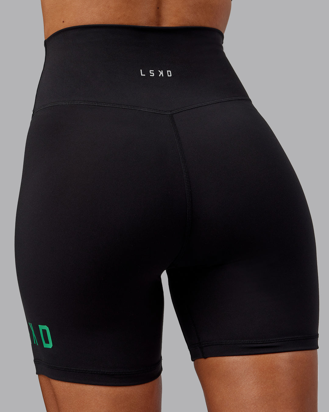 Woman wearing Evolved Mid Short Tights - Black-Impact Green