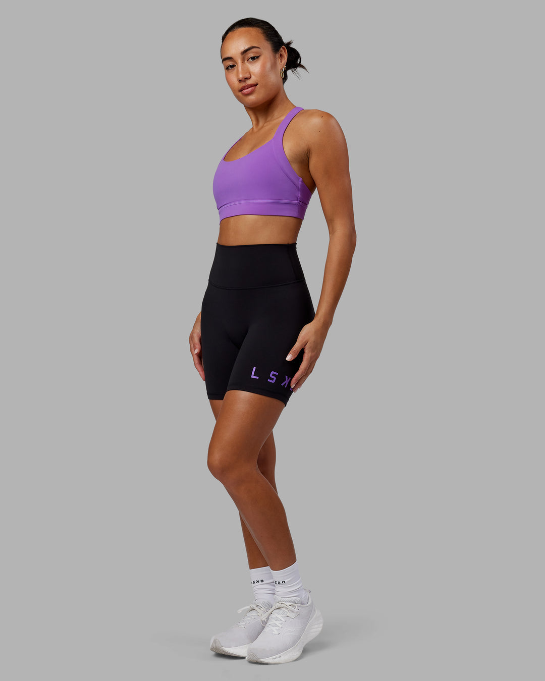 Woman wearing Evolved Mid Short Tights - Black-Purple Swirl