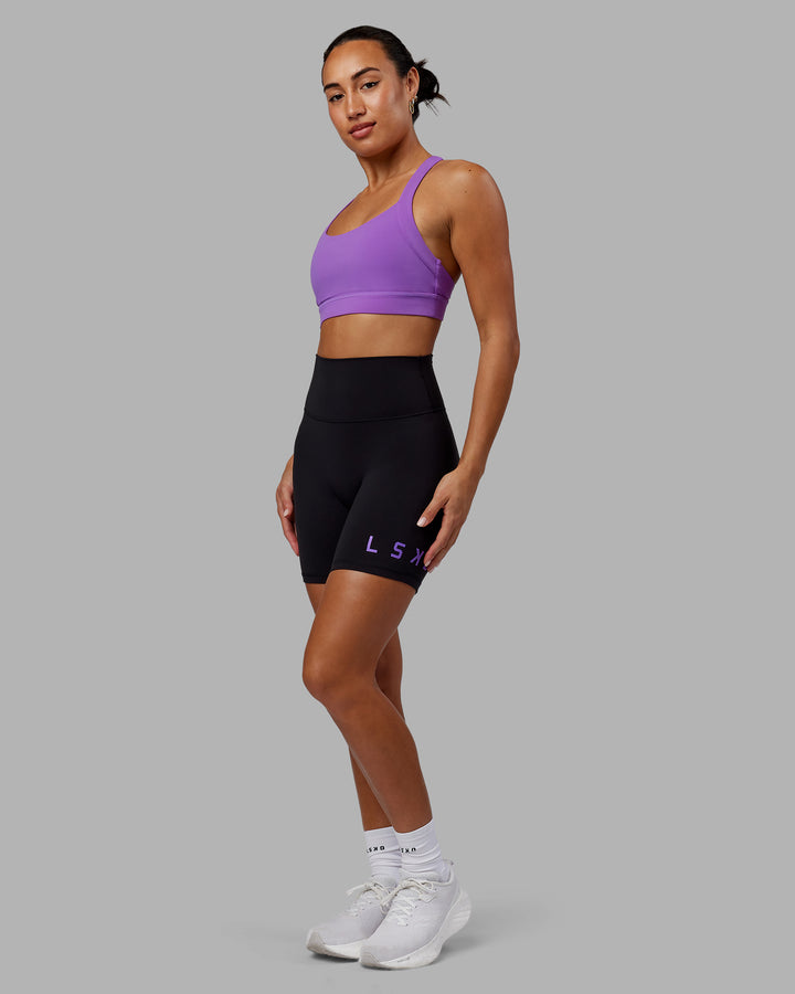 Woman wearing Evolved Mid Short Tights - Black-Purple Swirl
