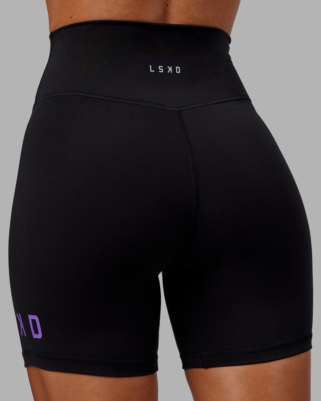 Woman wearing Evolved Mid Short Tights - Black-Purple Swirl