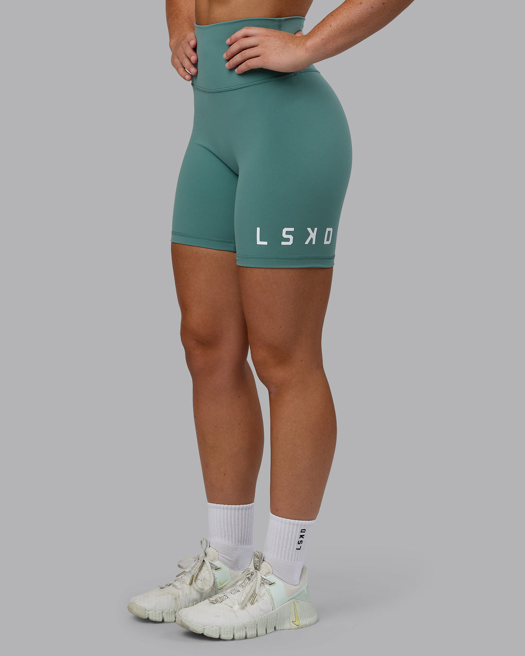 Woman wearing Evolved Mid Short Tights - Sagebrush-White