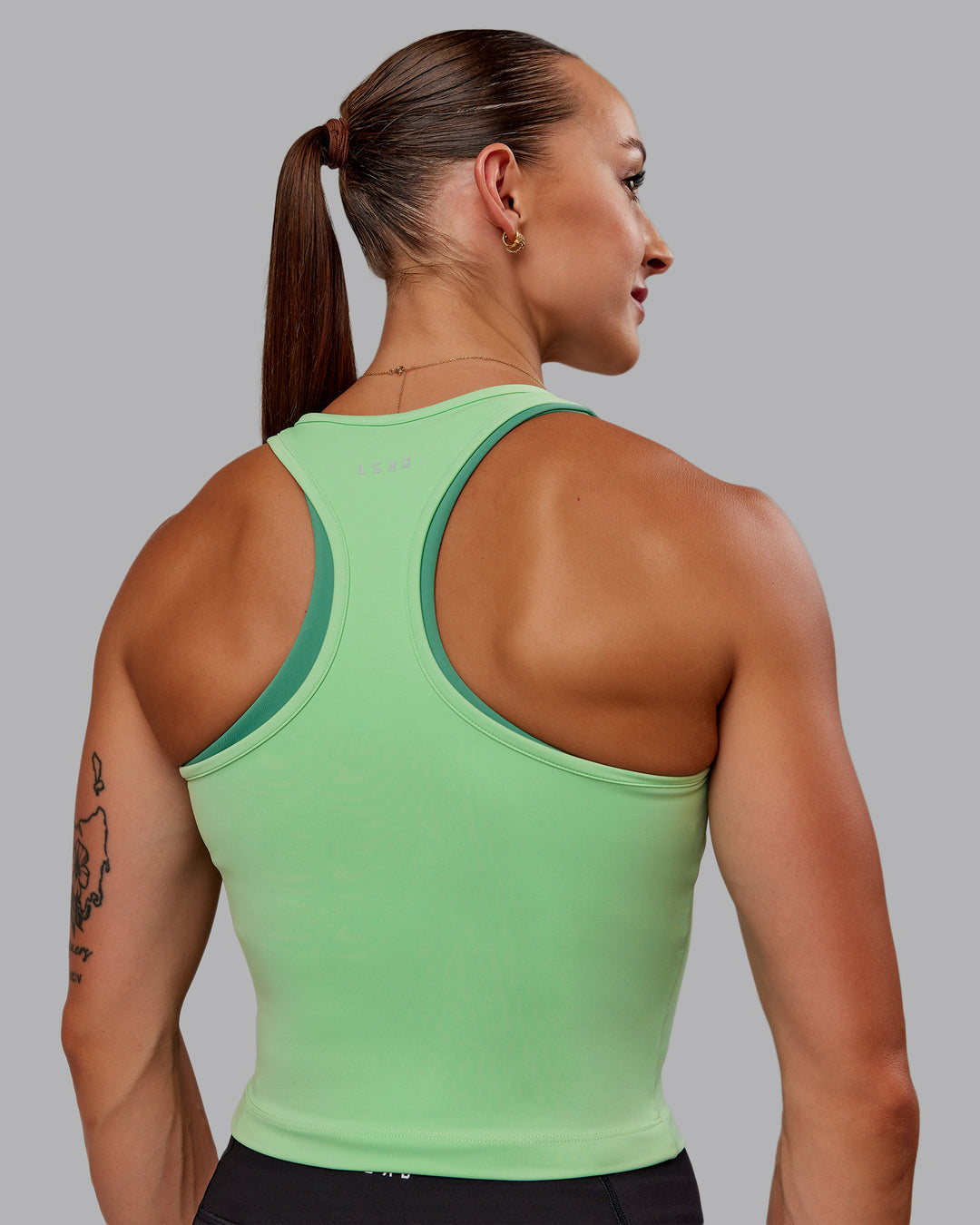 Woman wearing Flow Performance Tank - Surreal Green