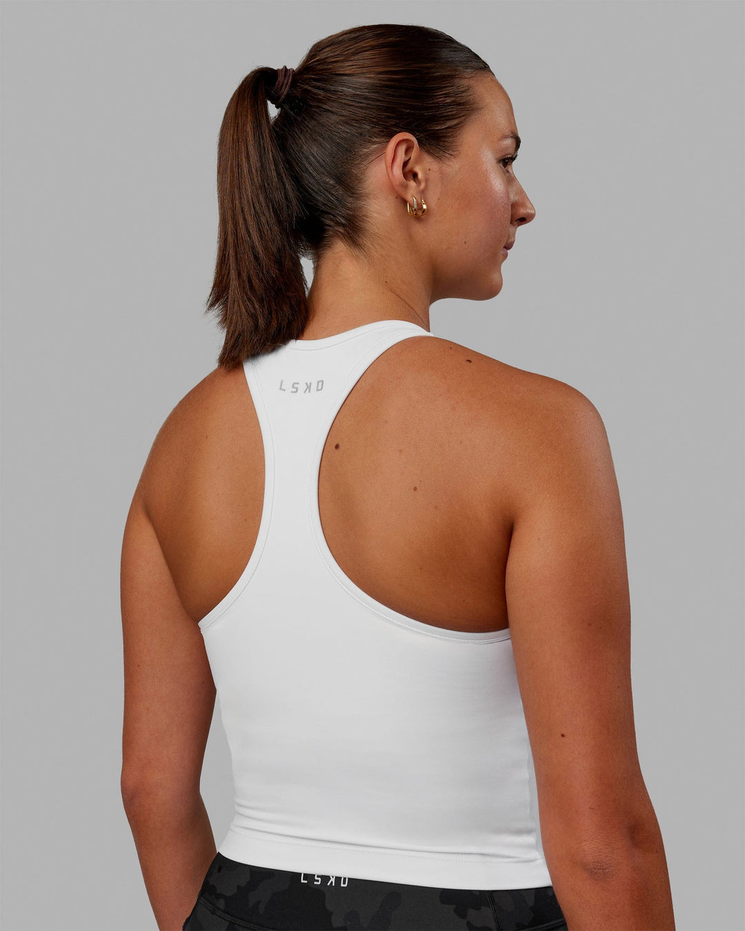 Woman wearing Flow Shelf Bra Performance Tank - White