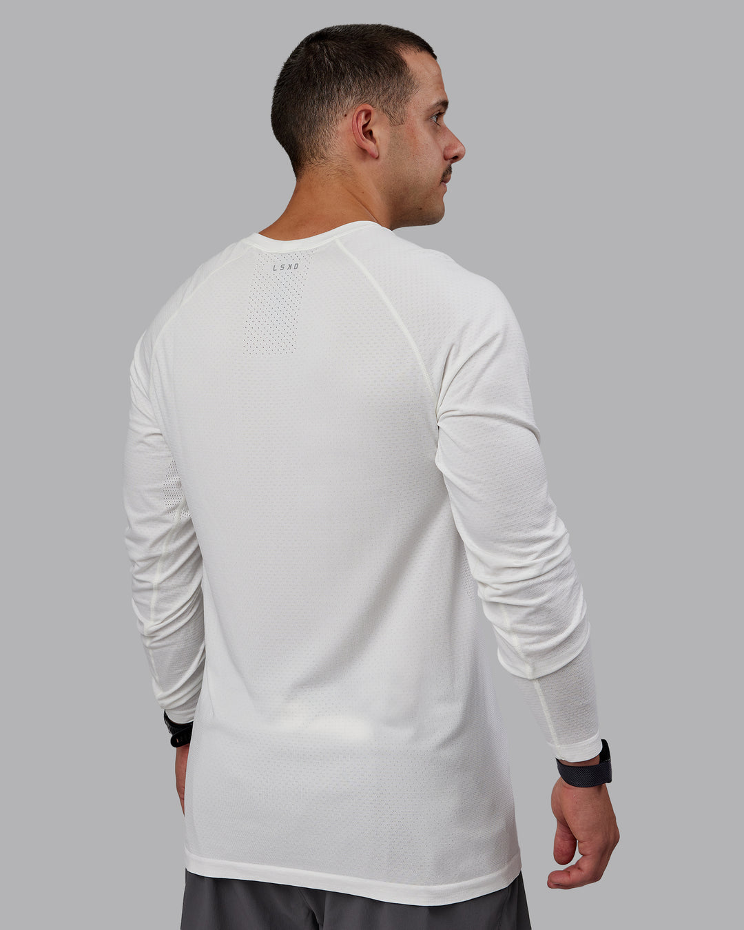 Man wearing AeroFLX+ Seamless Long Sleeve Tee - Off White/Off White Marl