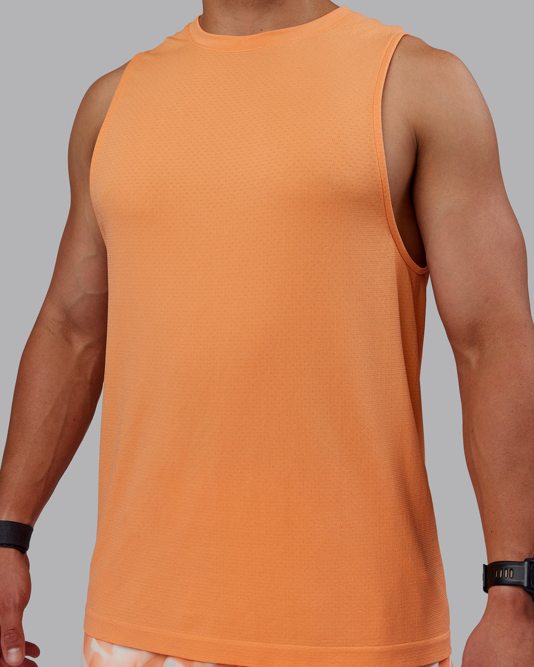 Man wearing AeroFLX+ Seamless Muscle Tank - Cantaloupe/Cantaloupe Marl