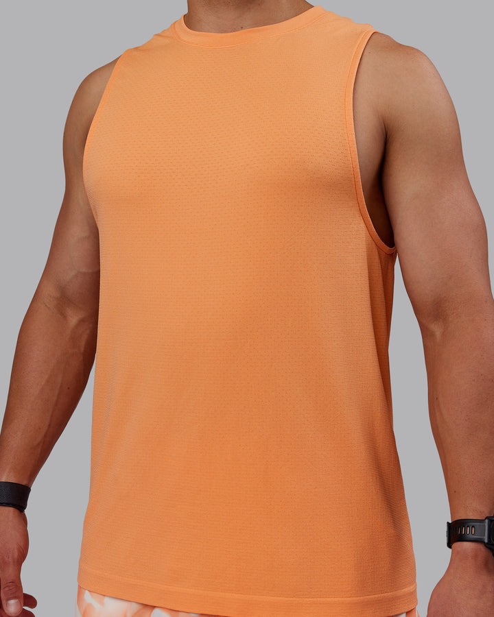 Man wearing AeroFLX+ Seamless Muscle Tank - Cantaloupe/Cantaloupe Marl
