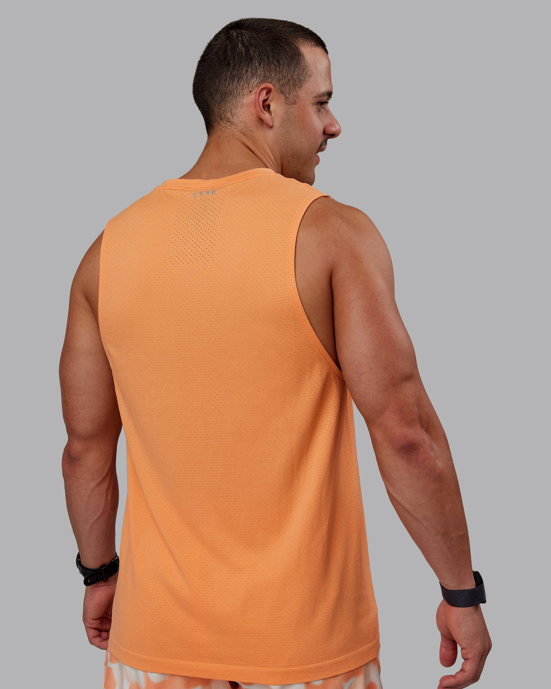 Man wearing AeroFLX+ Seamless Muscle Tank - Cantaloupe/Cantaloupe Marl