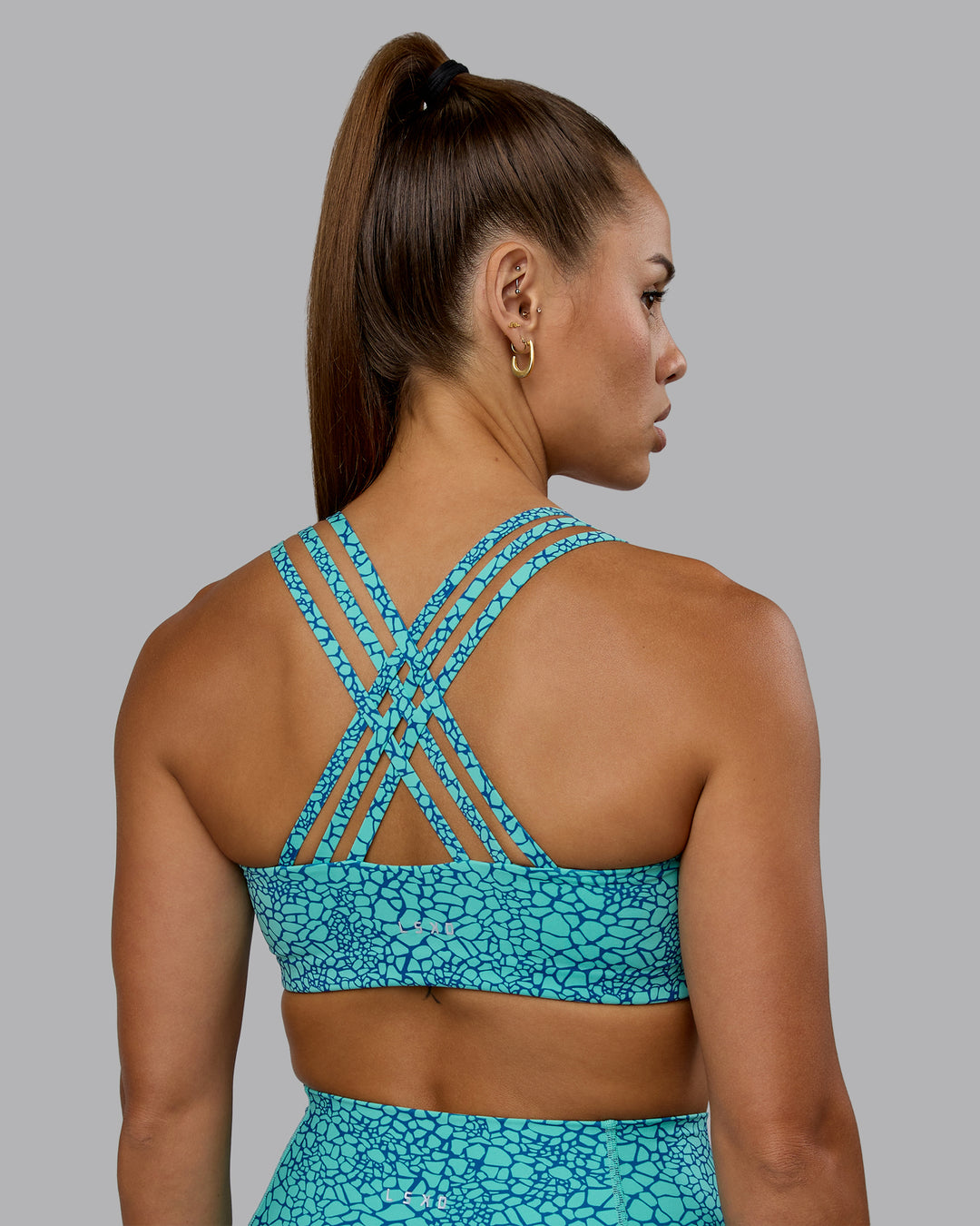 Woman wearing Push The Limit Sports Bra - Aquatic Awe Vitality Print