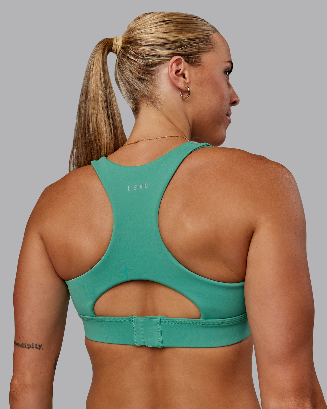 Woman wearing Race Day Sports Bra - Mystic Green