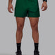 Man wearing Rep 5" Performance Shorts - Deep Emerald