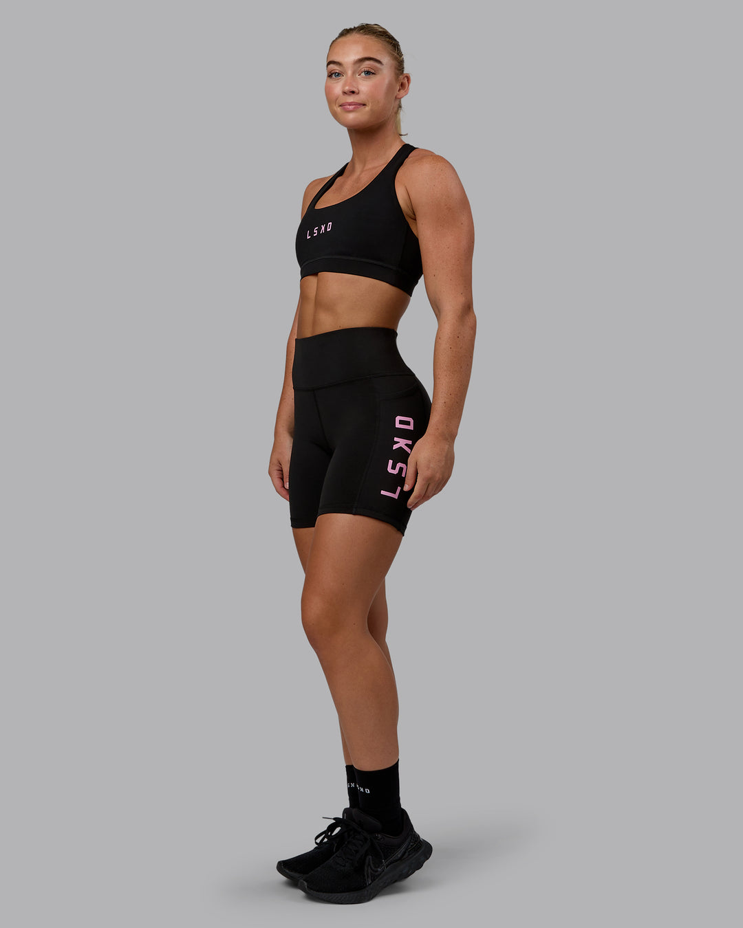 Woman wearing Rep Sports Bra - Black-Bubblegum