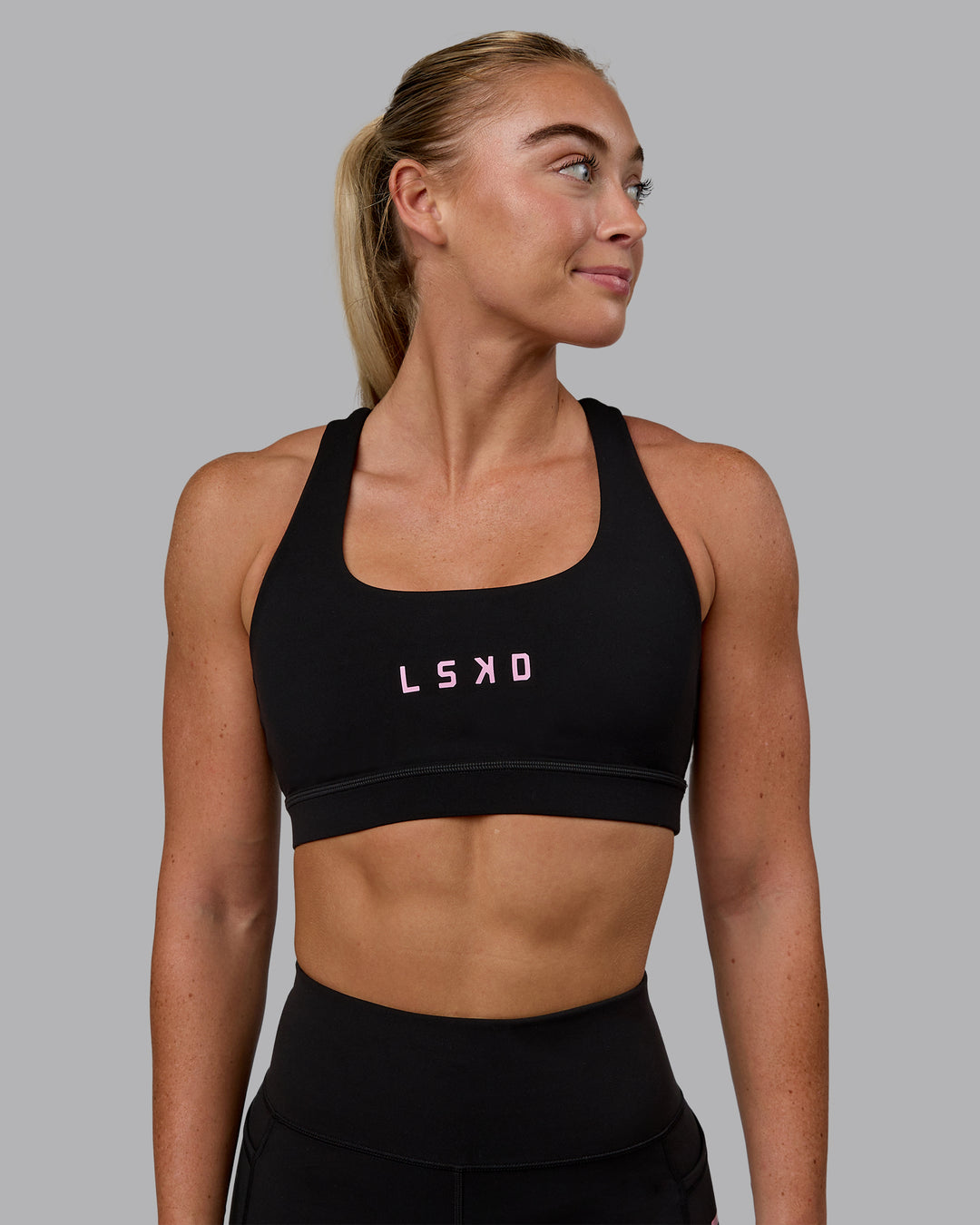 Woman wearing Rep Sports Bra - Black-Bubblegum