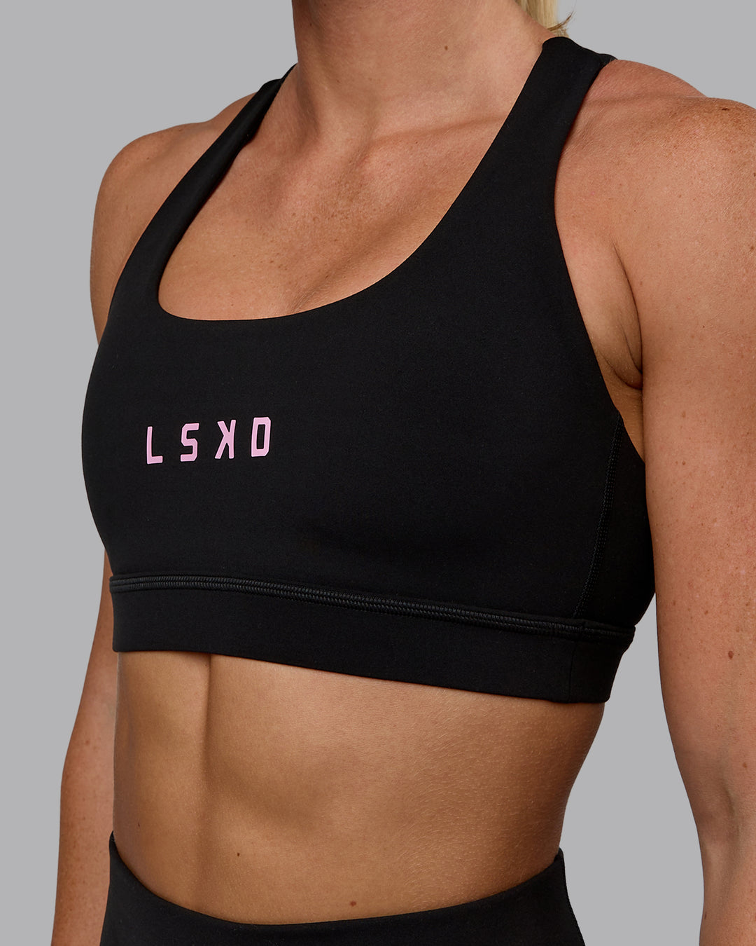 Woman wearing Rep Sports Bra - Black-Bubblegum