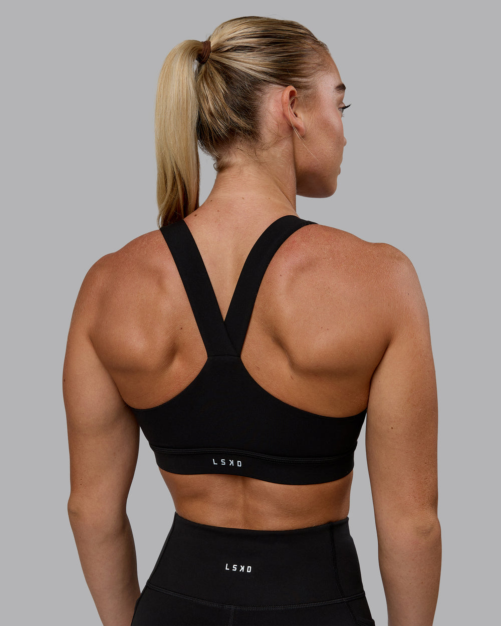 Woman wearing Rep Sports Bra - Black-Bubblegum