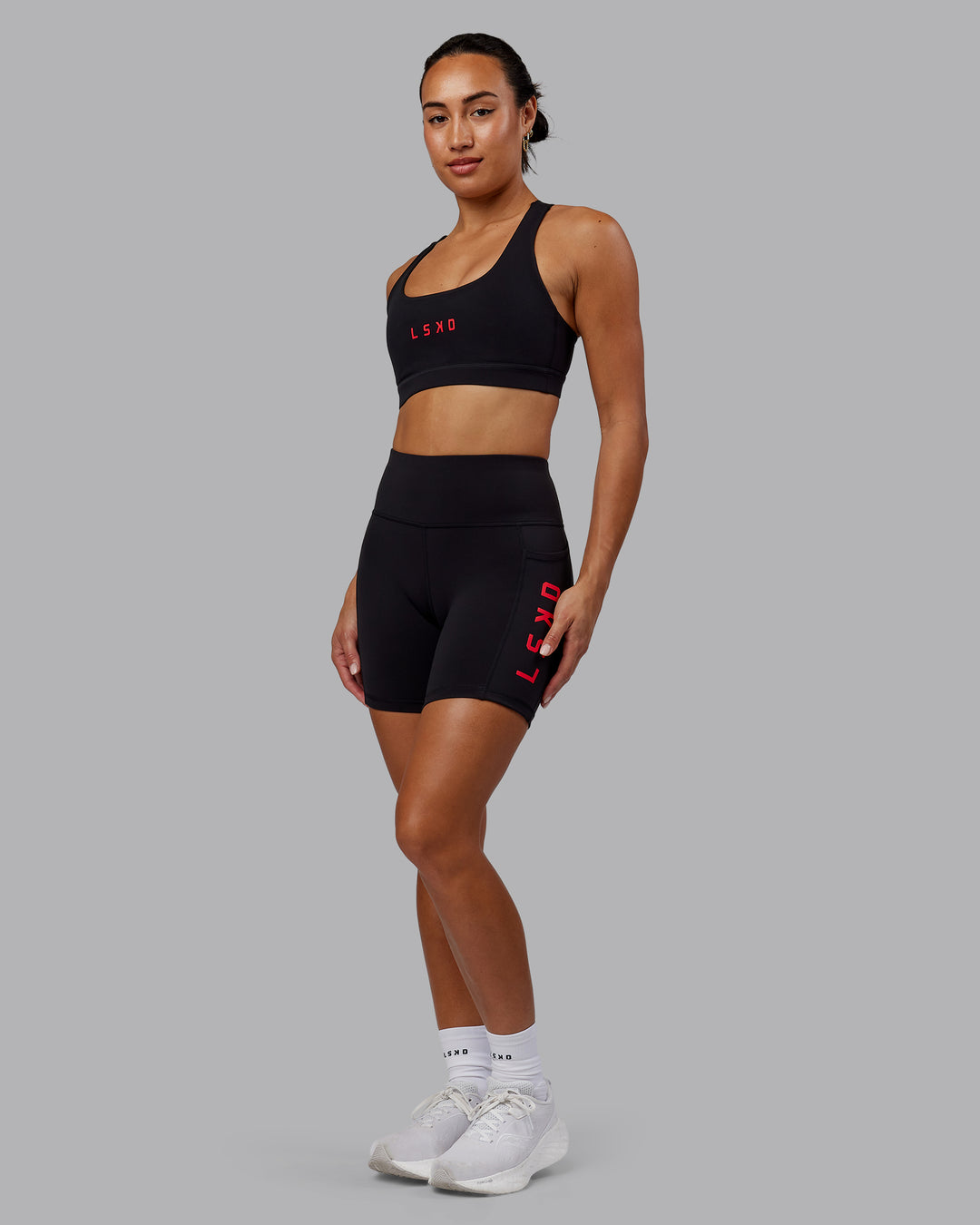 Woman wearing Rep Sports Bra - Black-Scarlet