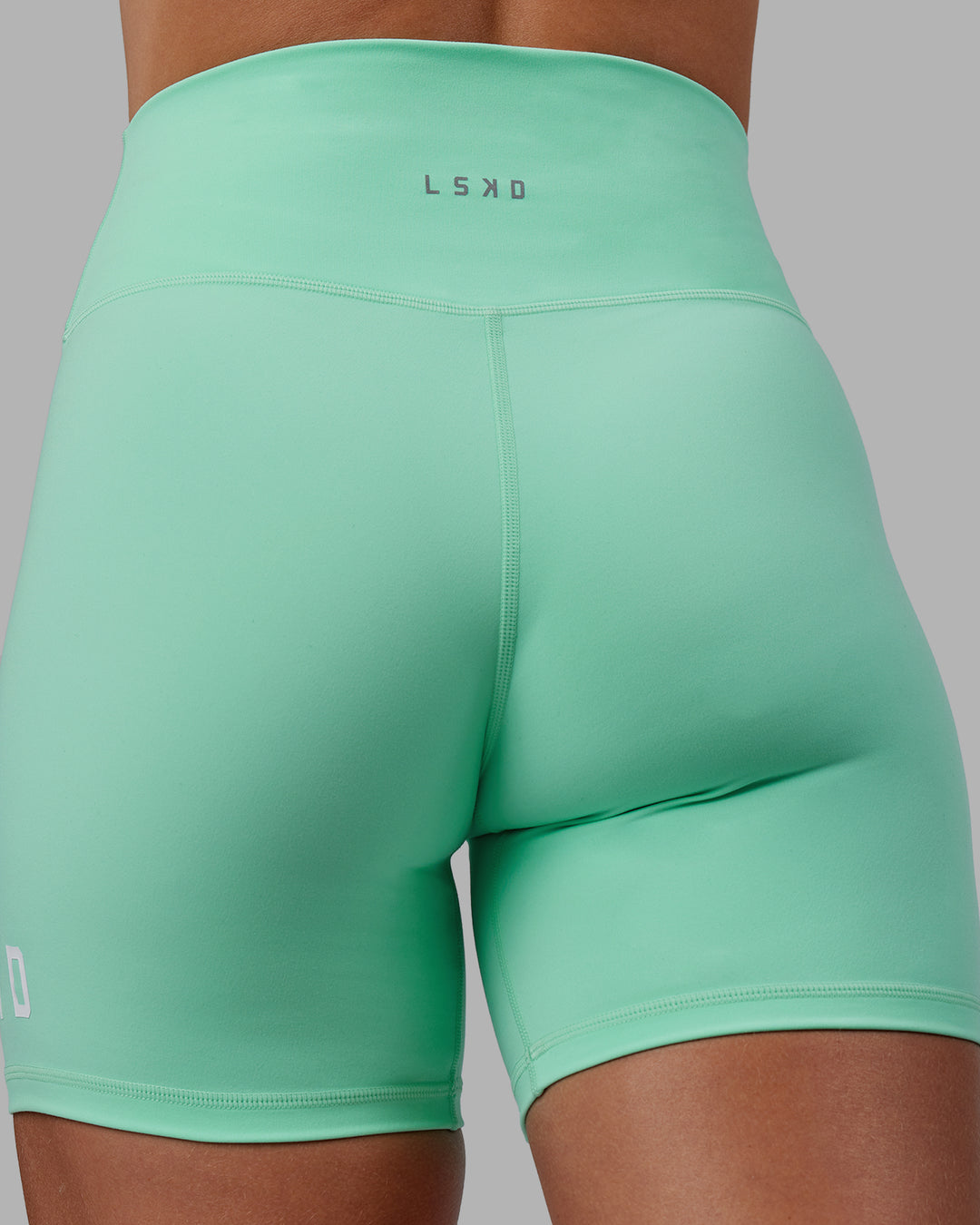 Woman wearing Shayna Jack X LSKD Evolved Mid Short Tights - Ice Green-White