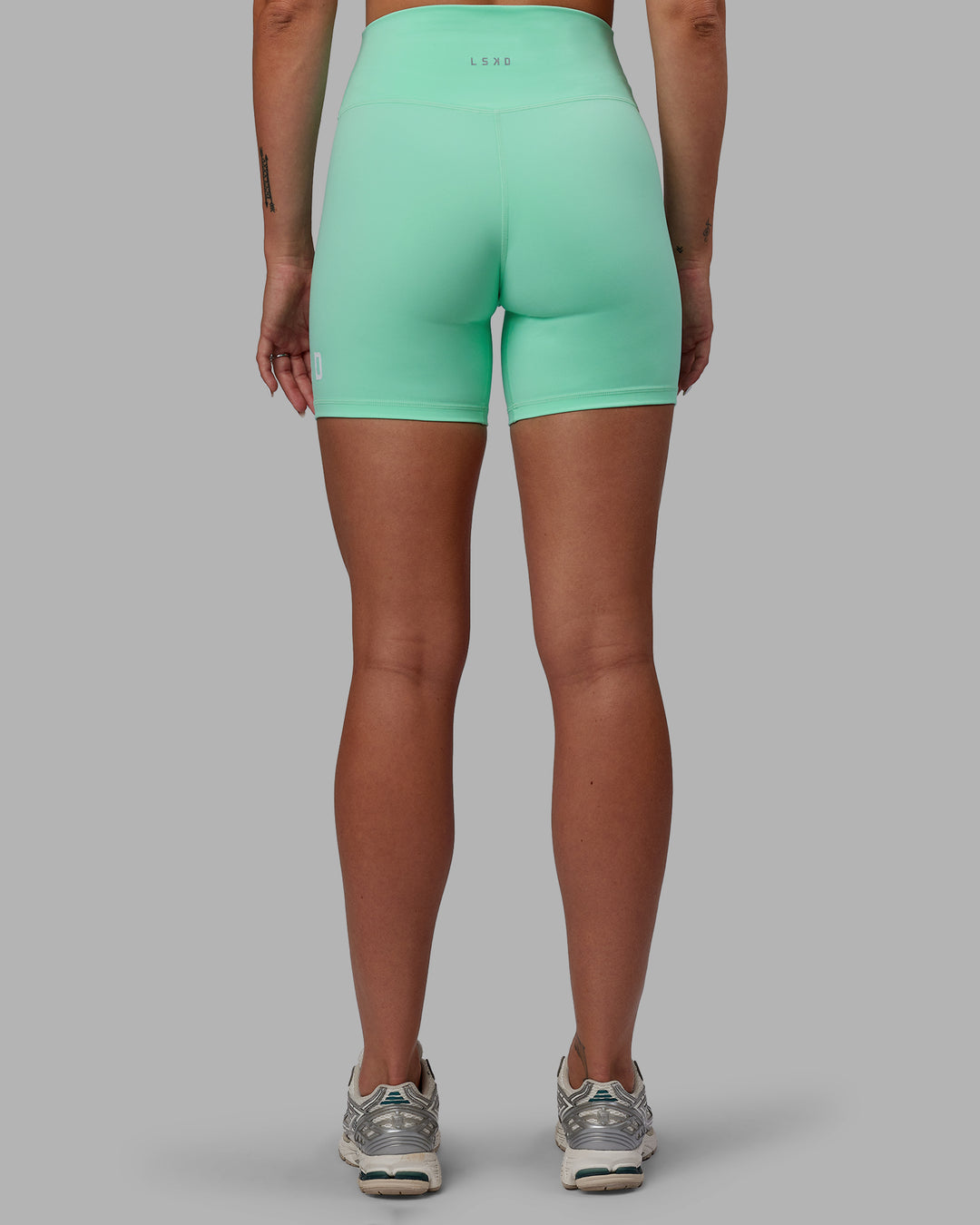 Woman wearing Shayna Jack X LSKD Evolved Mid Short Tights - Ice Green-White