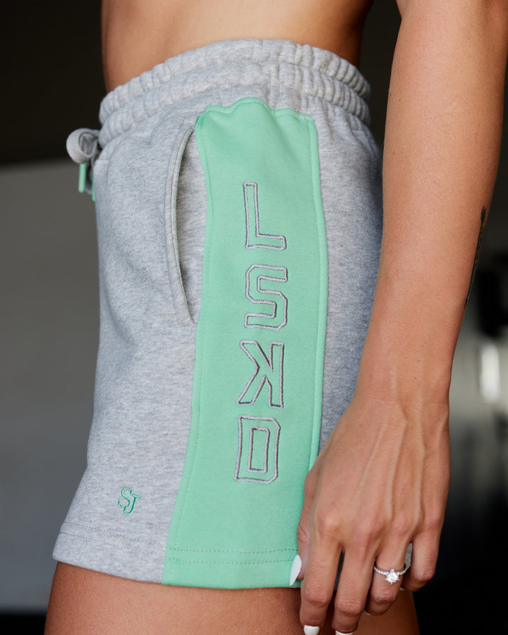 Woman wearing Tenacity Lounge Shorts - Light Grey Marl-Ice Green
