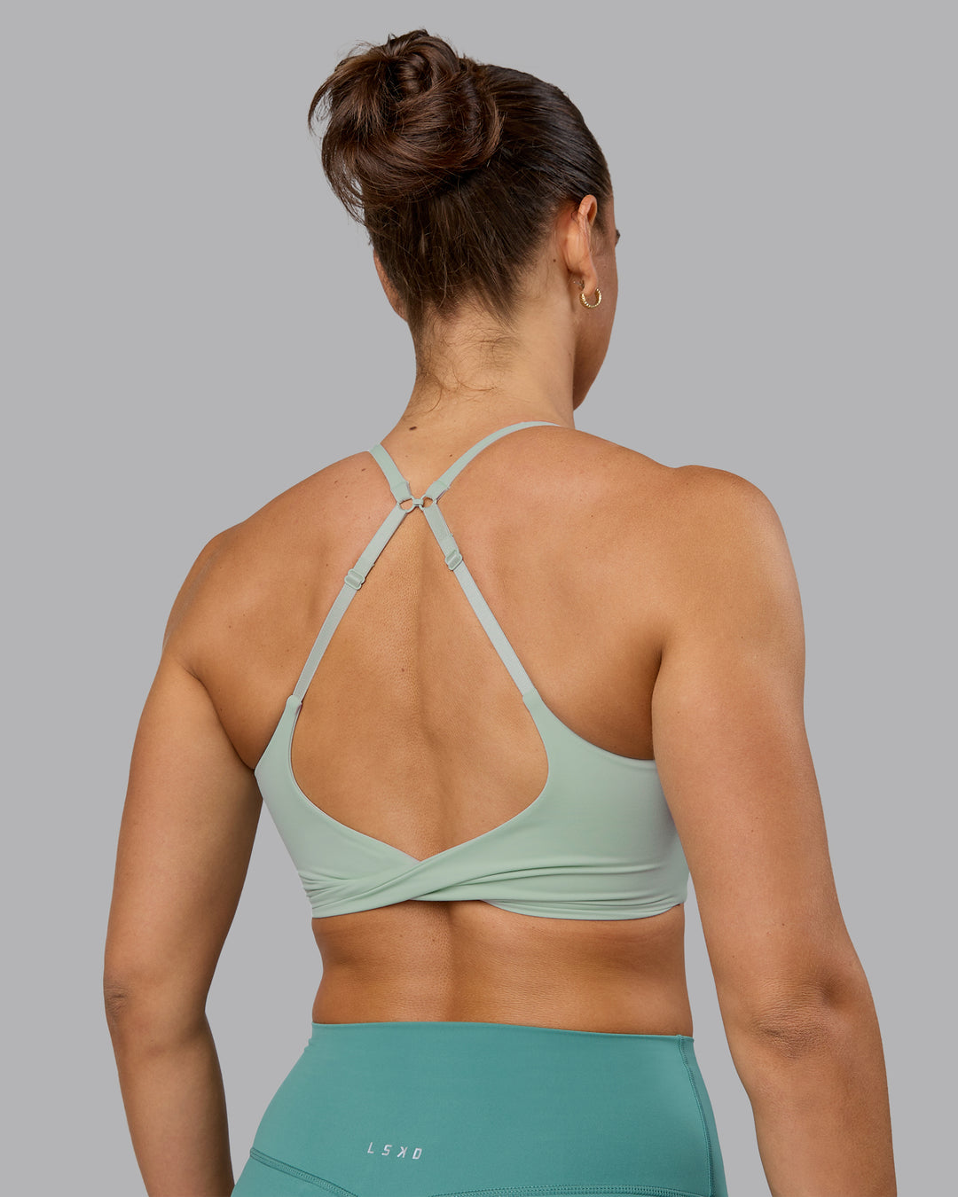 Woman wearing Twist Sports Bra - Surf Spray