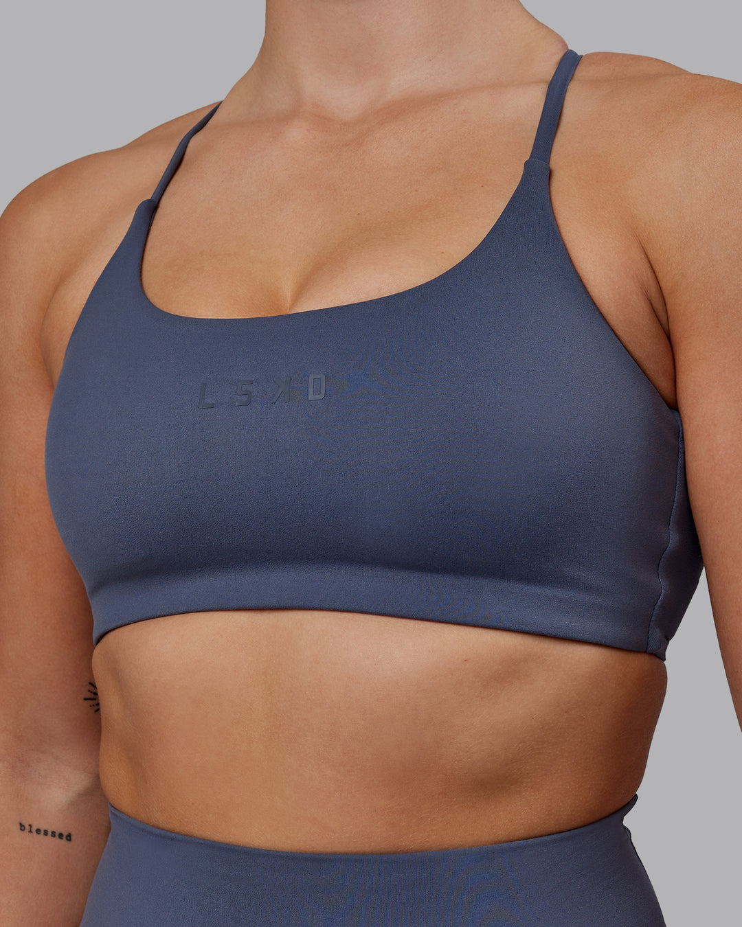 Woman wearing Twist Sports Bra - Turbulence