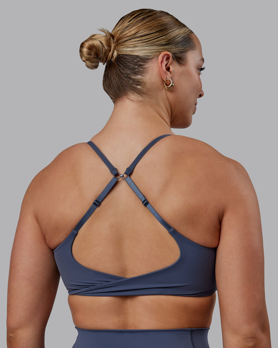 Woman wearing Twist Sports Bra - Turbulence