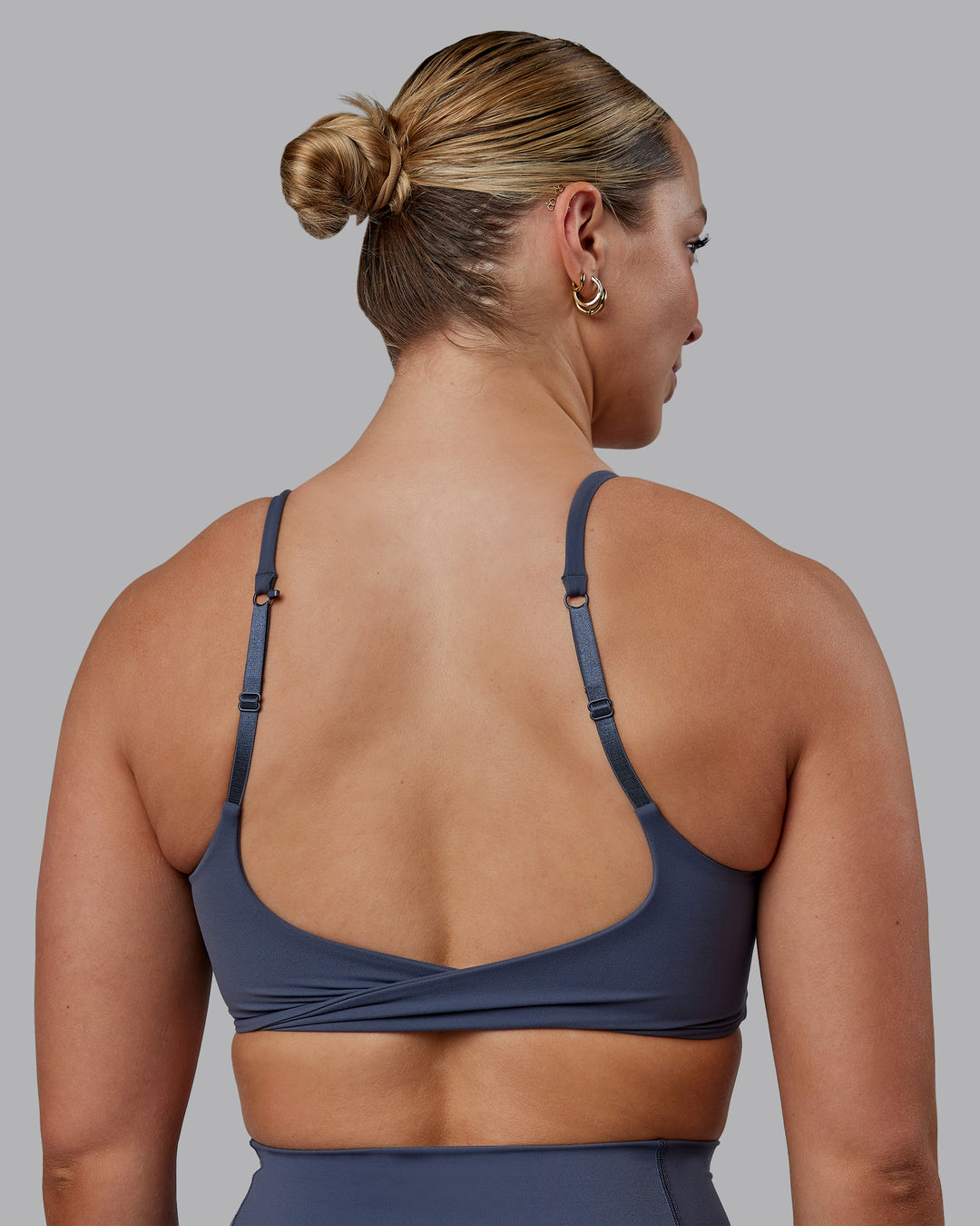 Woman wearing Twist Sports Bra - Turbulence