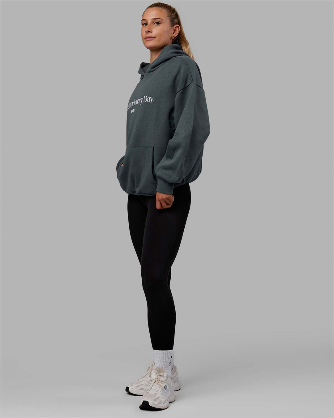 Woman wearing Unisex 1% Better Hoodie Oversize - Storm-White