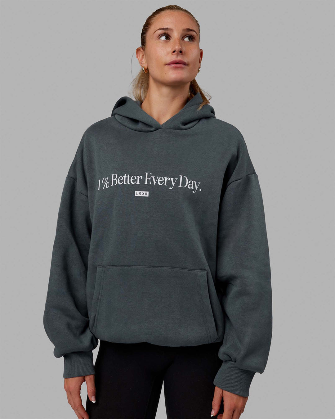 Woman wearing Unisex 1% Better Hoodie Oversize - Storm-White