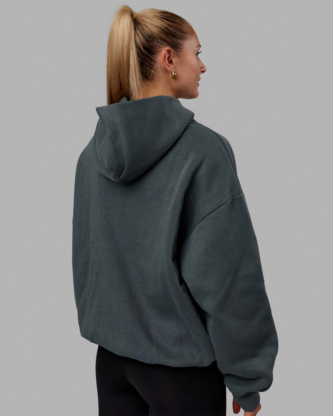 Woman wearing Unisex 1% Better Hoodie Oversize - Storm-White