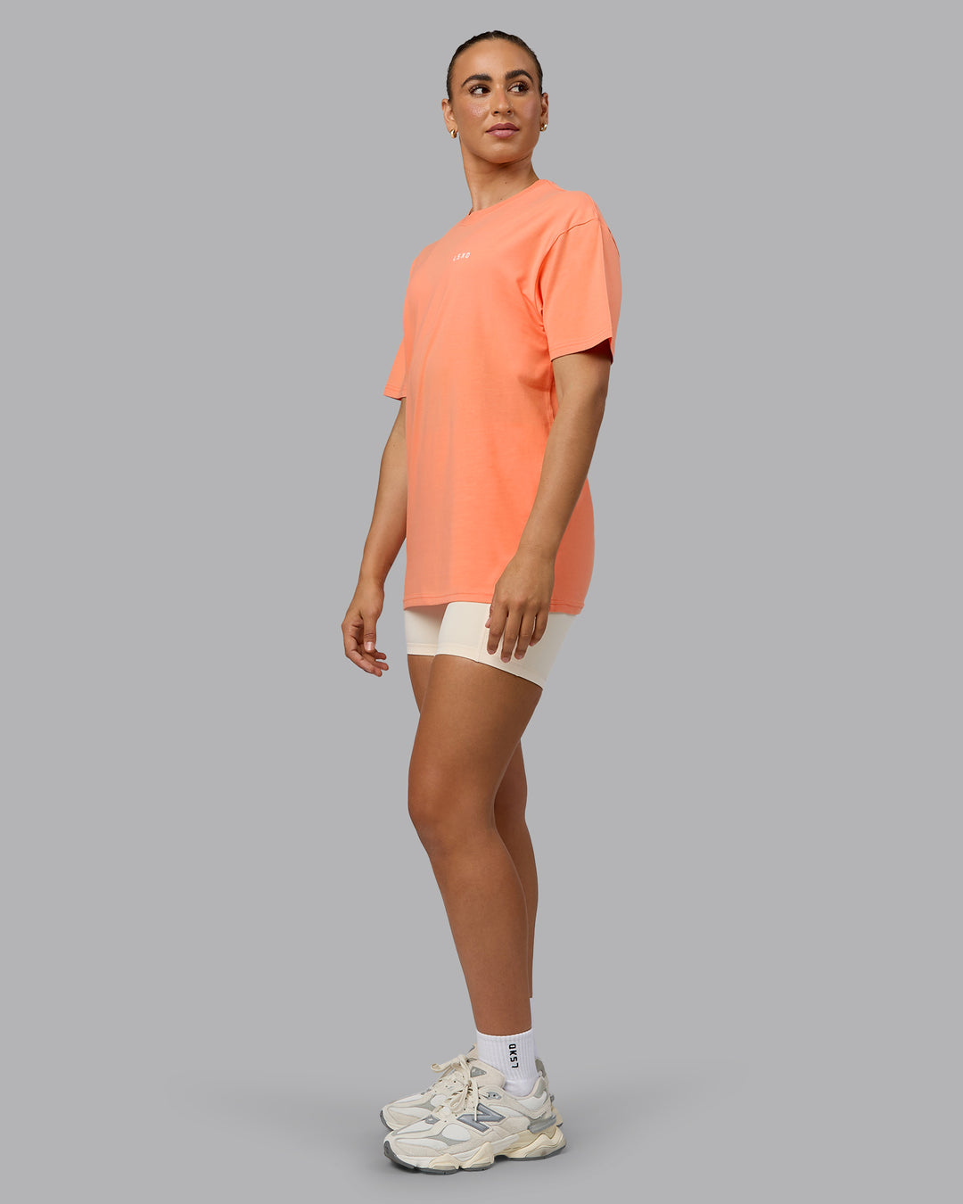 Woman wearing Unisex 1% Better Value Series FLXCotton Tee Oversize - Mellow Peach-White