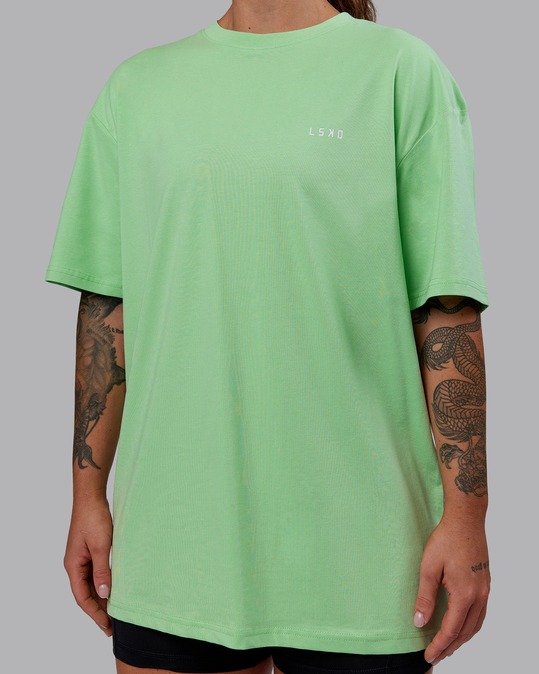 Woman wearing Unisex 1% Better Value Series FLXCotton Tee Oversize - Surreal Green-White