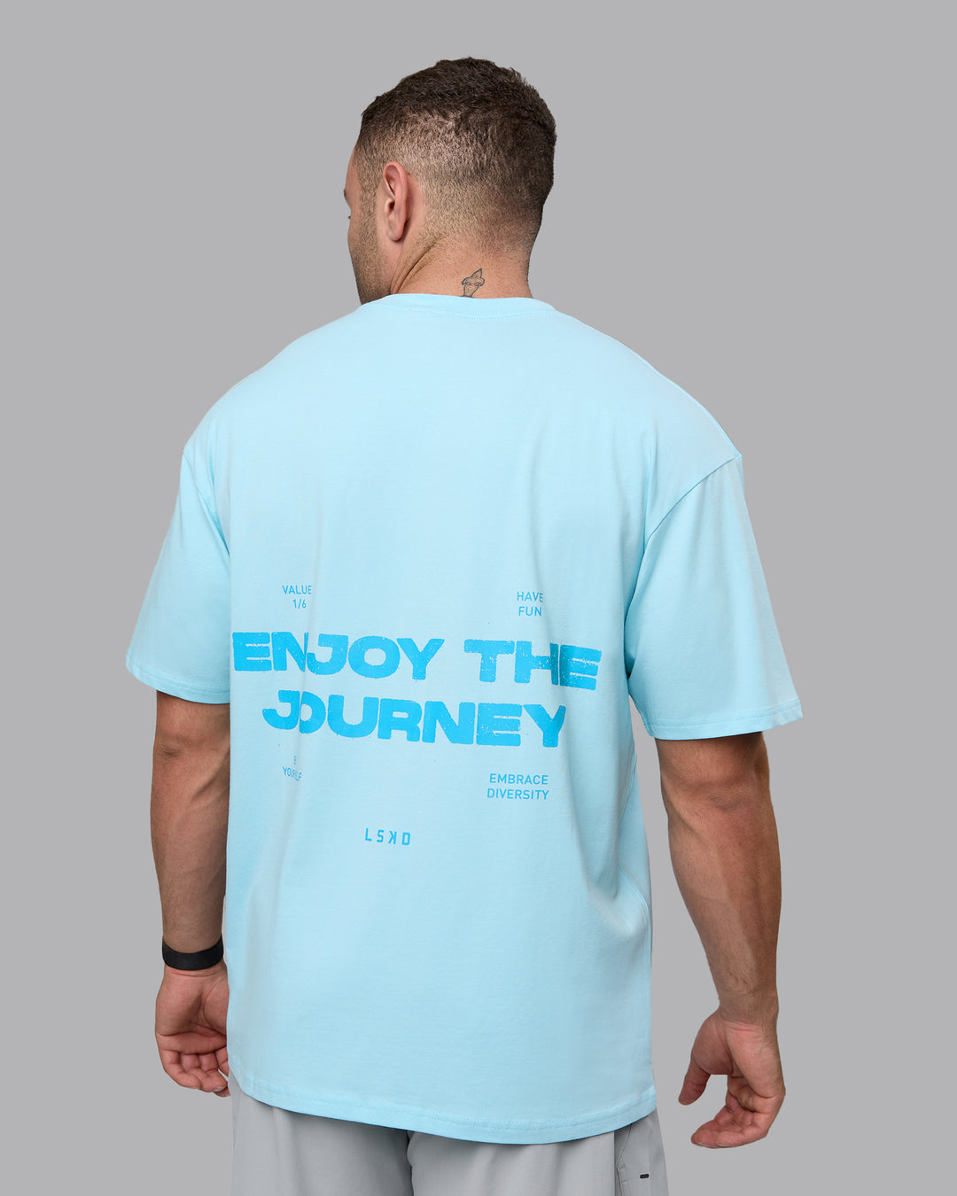 Man wearing Unisex Enjoy the Journey Value Series FLXCotton Tee Oversize - Crystal Blue-Bay Blue