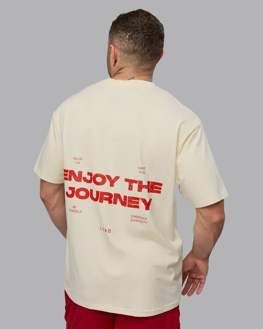 Man wearing Unisex Enjoy the Journey Value Series FLXCotton Tee Oversize - Ivory-Cherry Red