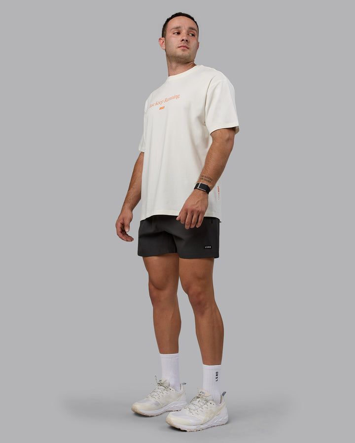 Man wearing Unisex Just Keep Running FLXCotton Tee Oversize - Off White-Vibrant Orange
